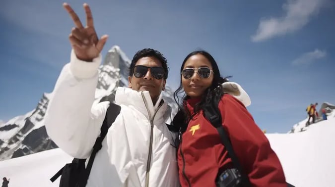 Two Indian tourists in skiwear pose on the Jungfraujoch